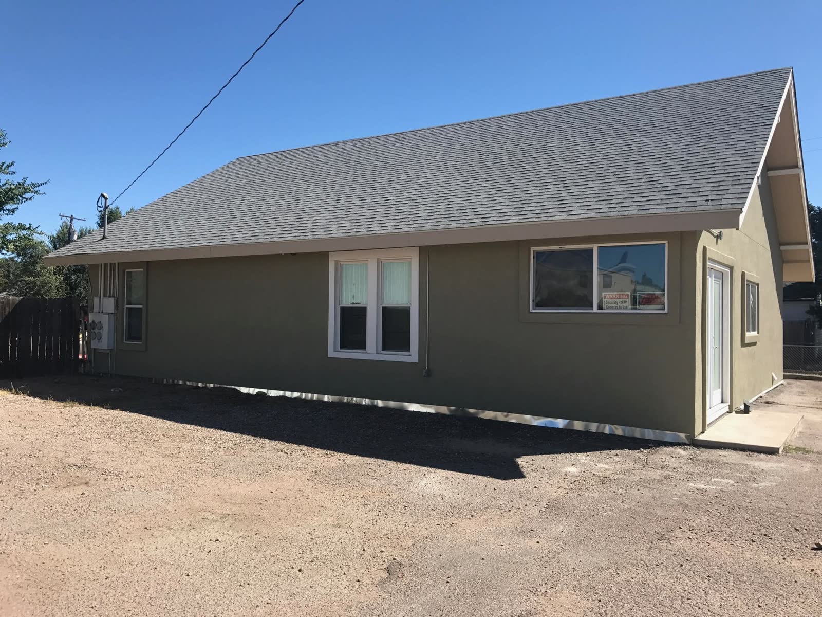 After: home refinished in a sage-green stucco coating