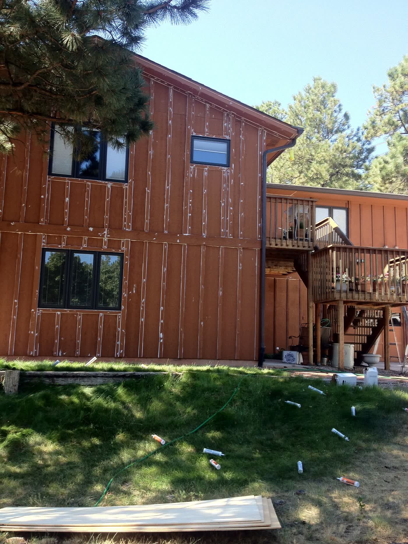 Before: faded board-and-batten siding showing prep marks