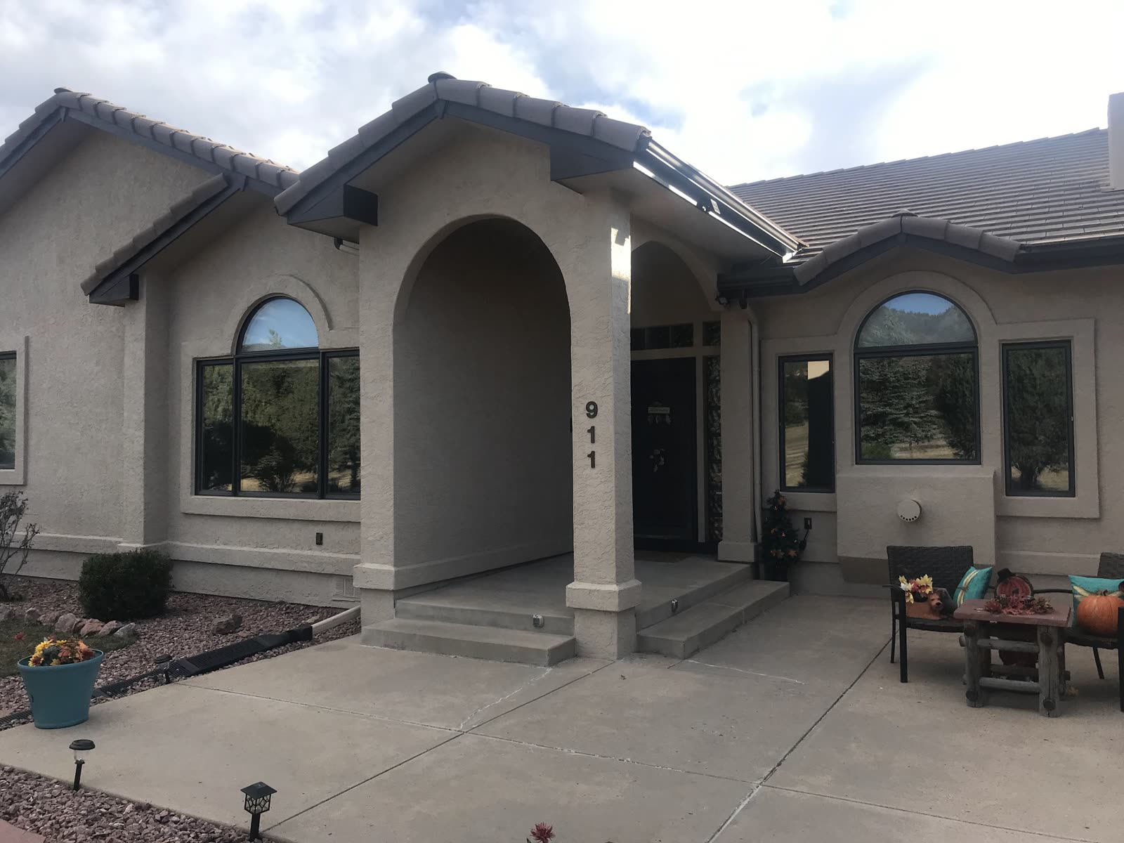 Mediterranean stucco home with arched portico and tile roof